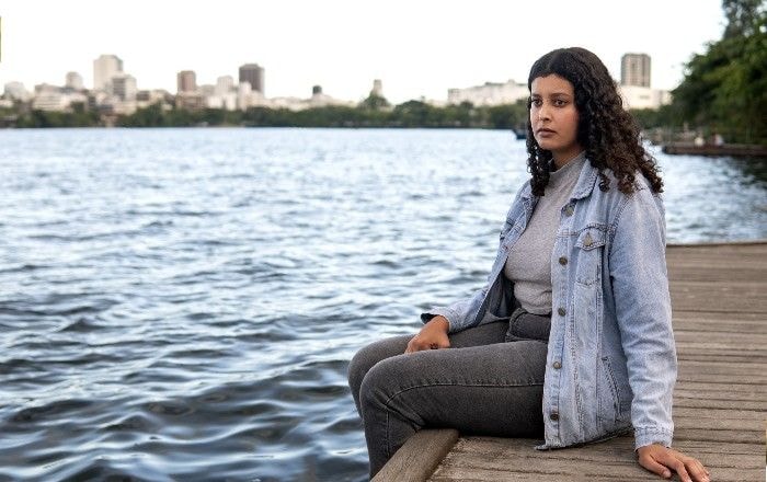 Sad Contemplative Woman Sitting by Lake